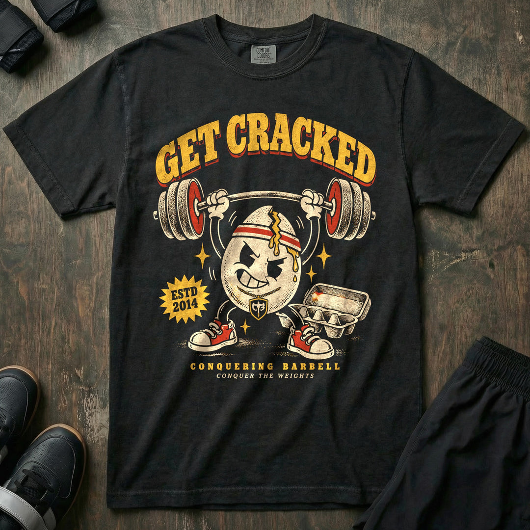 Get Cracked - Relaxed Fit Tee front graphic in Black with a cracked egg mascot in a headband pressing a barbell overhead - Conquering Barbell