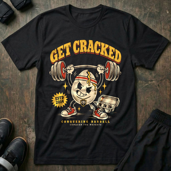 Get Cracked - Tee front graphic in Black with a cracked egg mascot in a headband pressing a barbell overhead - Conquering Barbell