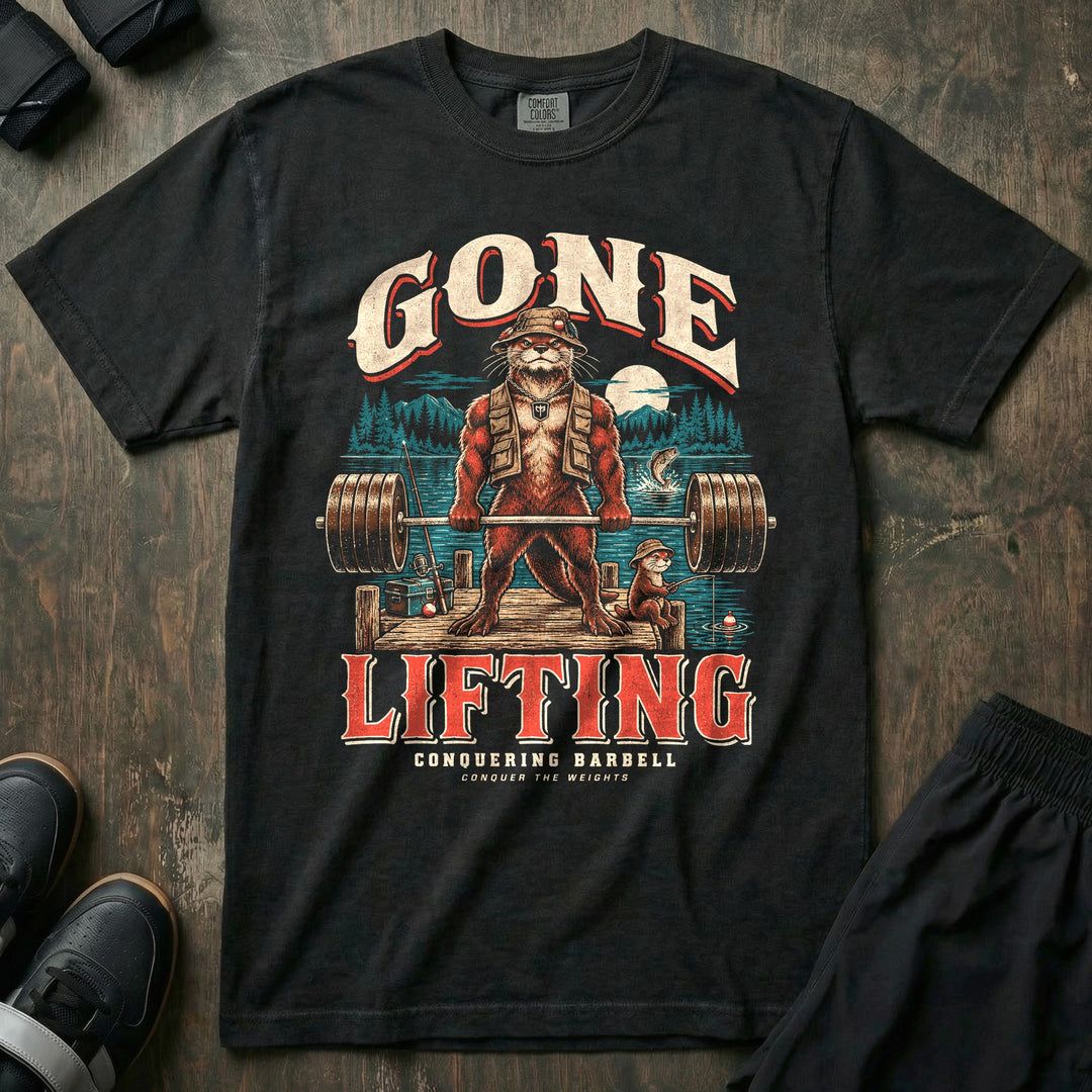 Gone Lifting - Relaxed Fit Tee front graphic in Black with an otter dad in a bucket hat and fishing vest deadlifting a loaded barbell on a lake dock while a young otter fishes - Conquering Barbell