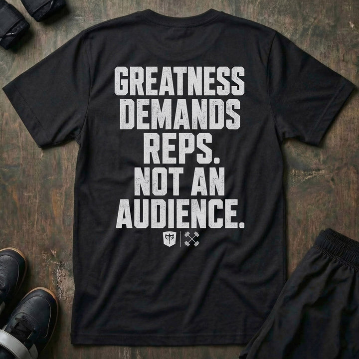 Greatness Demands Reps. Not an Audience. tee in Black: the full statement in oversized distressed block lettering stacked