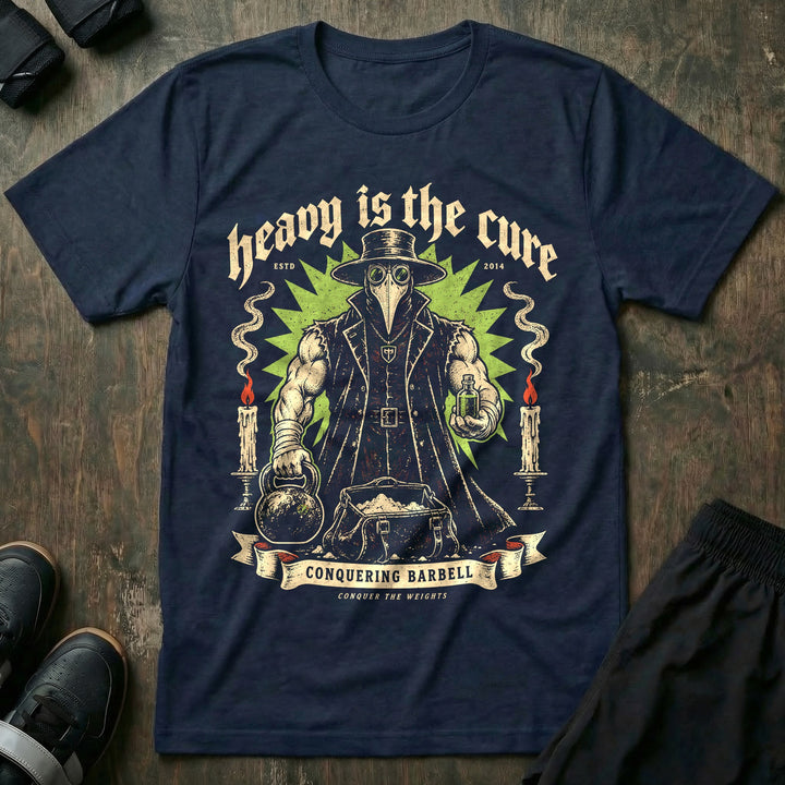 Heavy Is the Cure - Tee front graphic in Navy with a muscular plague doctor holding a kettlebell and a vial - Conquering Barbell