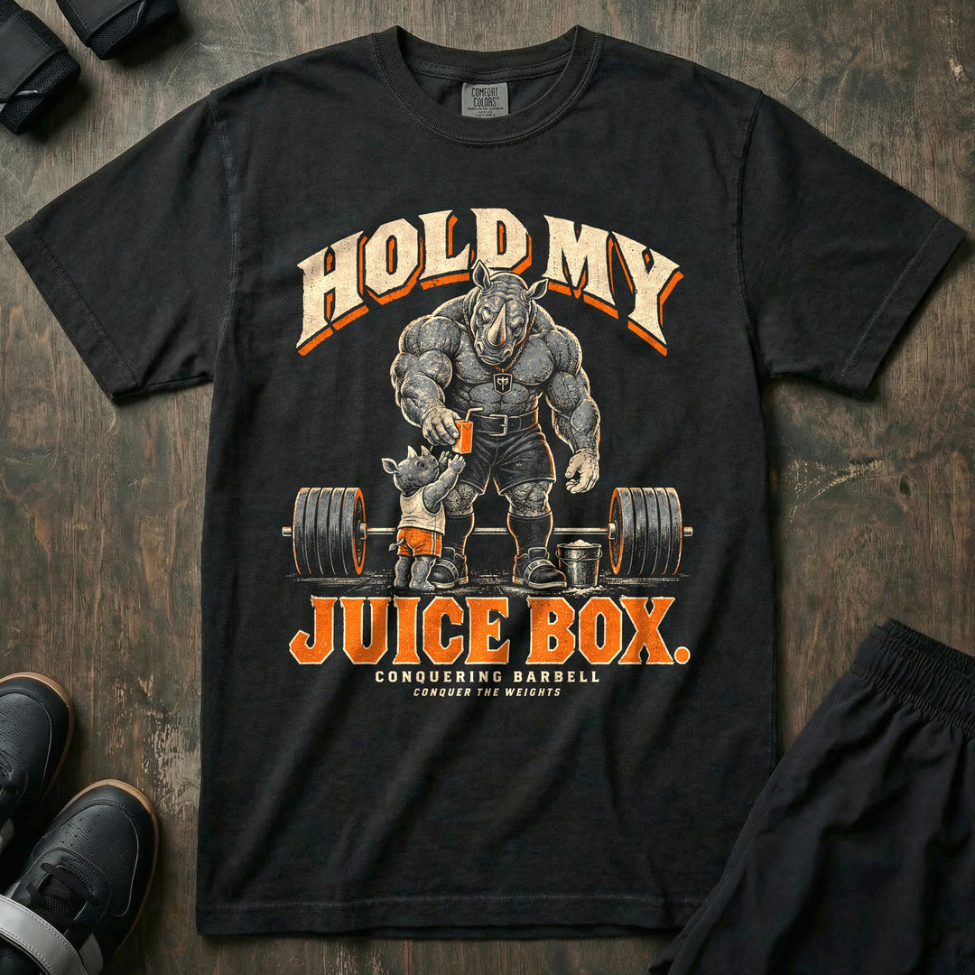 Hold My Juice Box - Relaxed Fit Tee front graphic in Black with a muscular rhino dad handing a juice box to a young rhino in front of a loaded barbell and a chalk bucket - Conquering Barbell