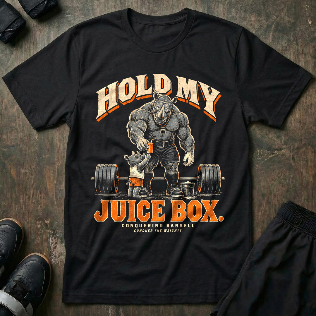 Hold My Juice Box - Tee front graphic in Black with a muscular rhino dad handing a juice box to a young rhino in front of a loaded barbell and a chalk bucket - Conquering Barbell
