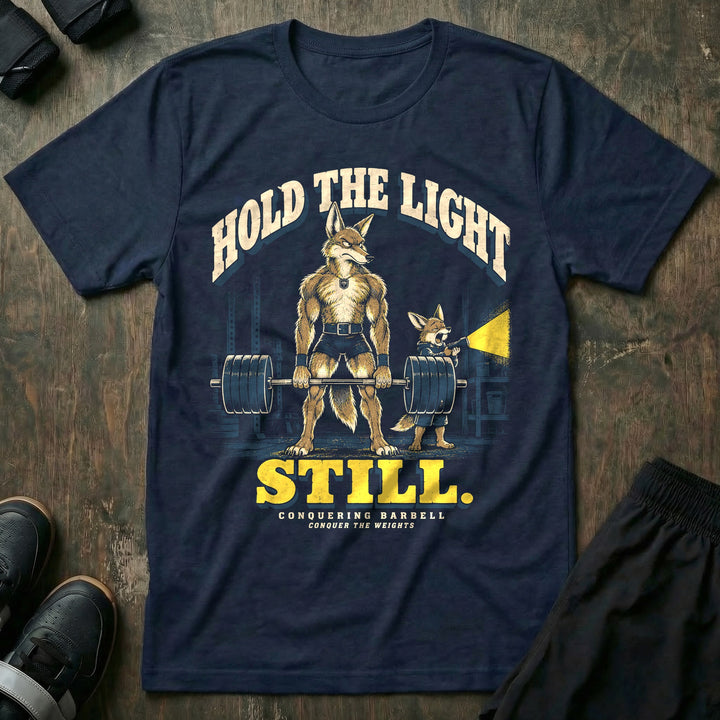 Hold the Light Still - Tee front graphic in Navy with a coyote dad deadlifting a loaded barbell in a dark garage while a yawning coyote pup holds a flashlight - Conquering Barbell