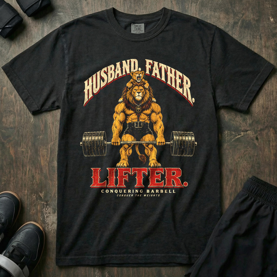 Husband. Father. Lifter - Relaxed Fit Tee front graphic in Black with a lion deadlifting a loaded barbell with a roaring lion cub on his shoulders - Conquering Barbell