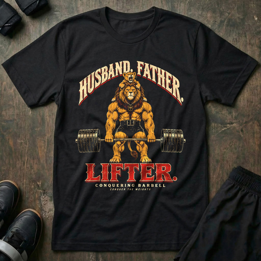 Husband. Father. Lifter - Tee front graphic in Black with a lion deadlifting a loaded barbell with a roaring lion cub on his shoulders - Conquering Barbell