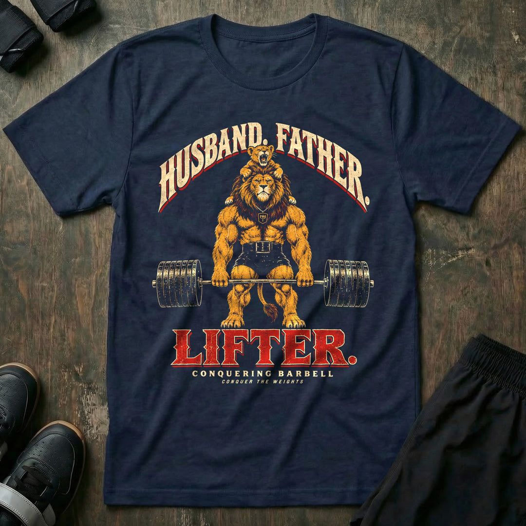 Husband. Father. Lifter - Tee front graphic in Navy with a lion deadlifting a loaded barbell with a roaring lion cub on his shoulders - Conquering Barbell
