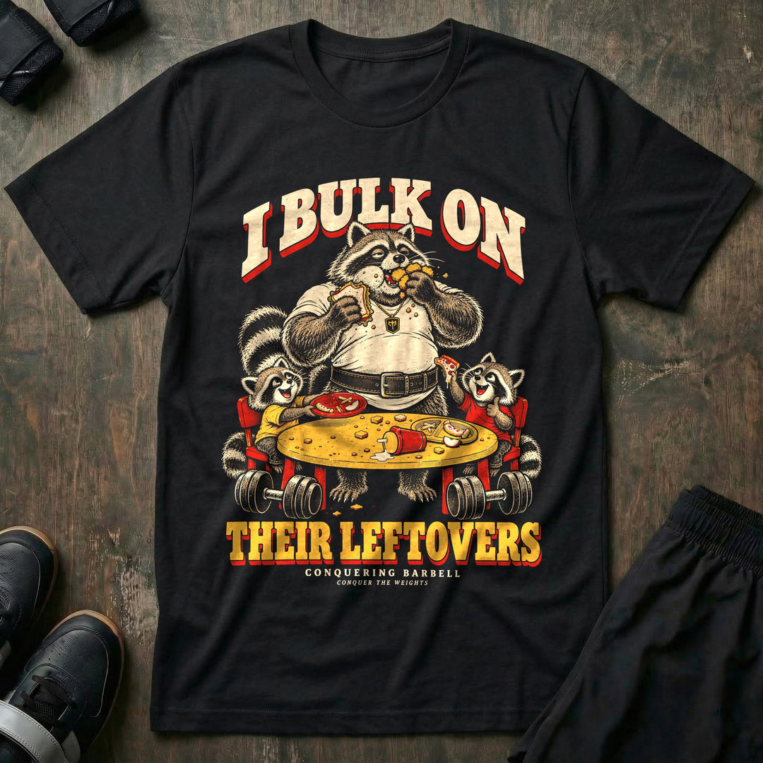 I Bulk on Their Leftovers - Tee front graphic in Black with a heavyset raccoon dad eating a sandwich and nuggets at the kids&