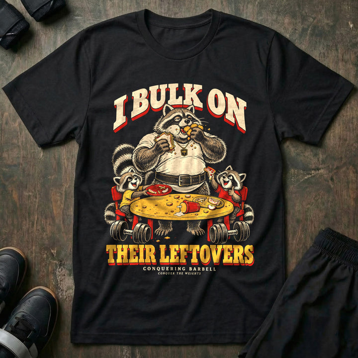 I Bulk on Their Leftovers - Tee front graphic in Black with a heavyset raccoon dad eating a sandwich and nuggets at the kids&