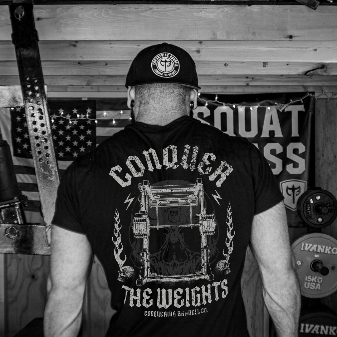 The Monolift tee in Black: a loaded monolift with a skull hidden inside the frame and flames at its sides
