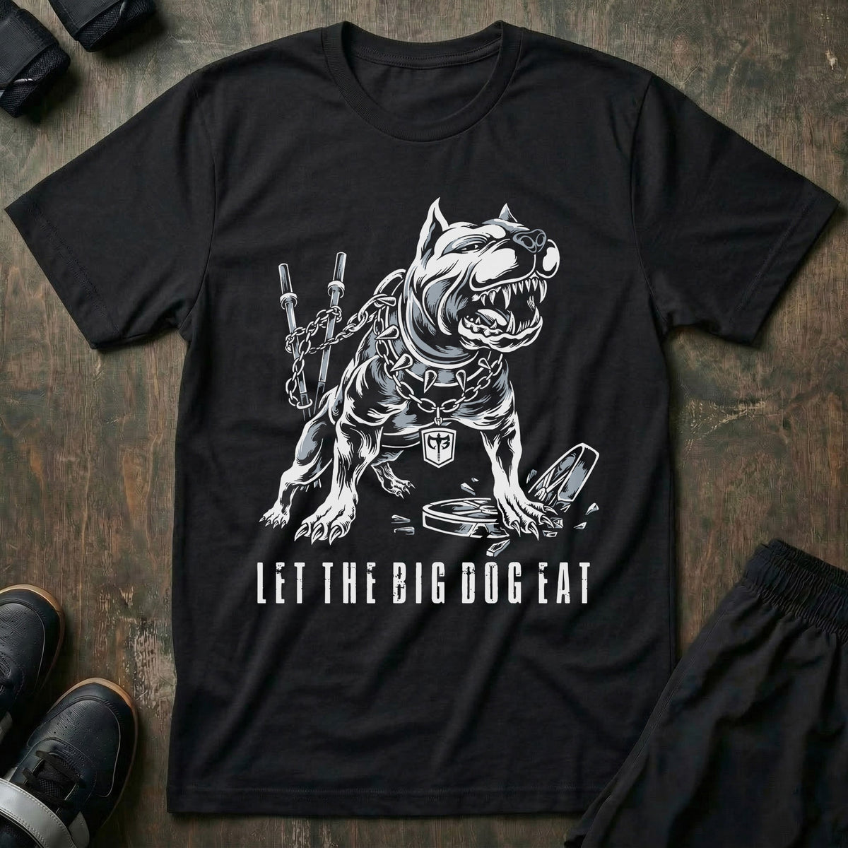 Let the Big Dog Eat tee in Black: a jacked pit bull in a spiked collar posted up beside a loaded barbell