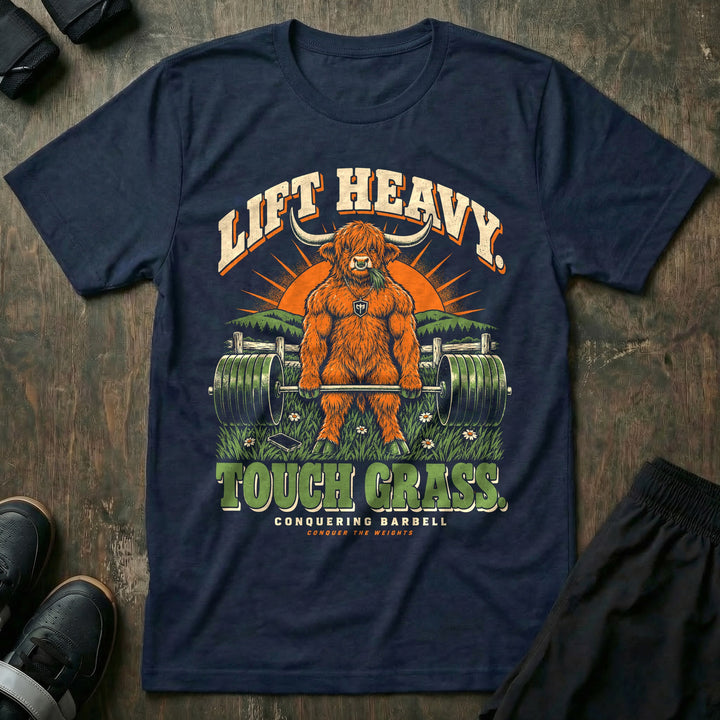 Lift Heavy Touch Grass - Tee front graphic in Navy with a Highland bull chewing grass at deadlift lockout in a meadow - Conquering Barbell