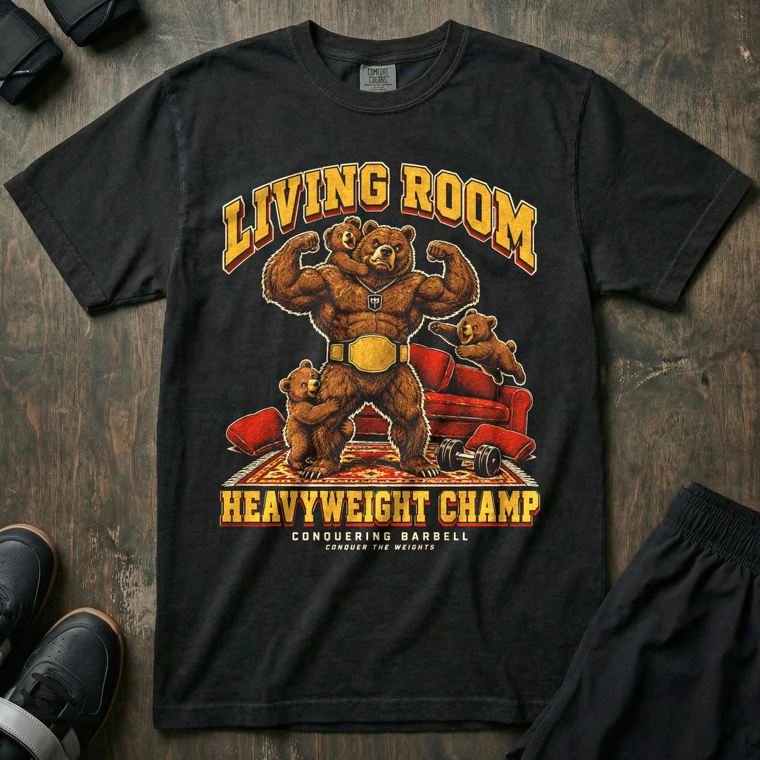 Living Room Heavyweight Champ - Relaxed Fit Tee front graphic in Black with a brown bear dad flexing in a gold championship belt while three bear cubs climb on him in a living room - Conquering Barbell