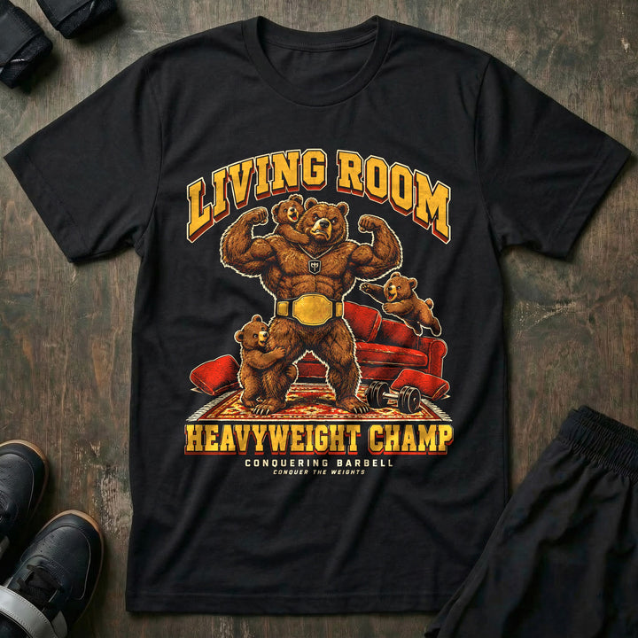 Living Room Heavyweight Champ - Tee front graphic in Black with a brown bear dad flexing in a gold championship belt while three bear cubs climb on him in a living room - Conquering Barbell