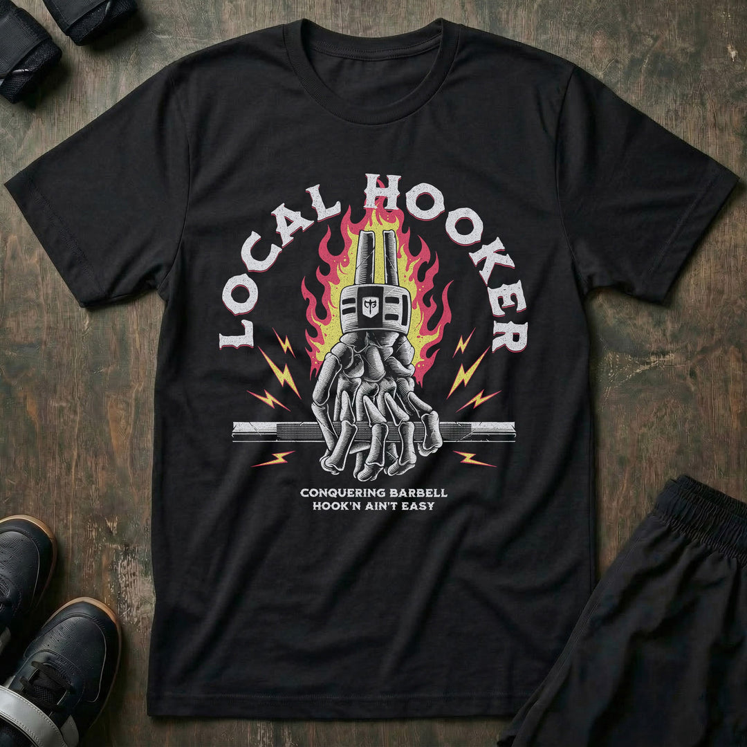 Local Hooker tee in Black: a skeleton hand locked in a hook grip on a barbell in front of roaring flames and lightning