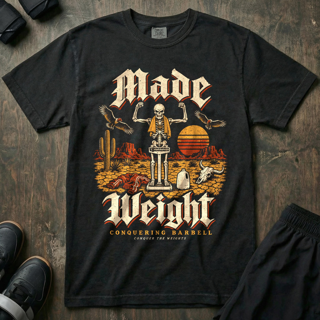 Made Weight - Relaxed Fit Tee front graphic in Black with a skeleton flexing on a balance scale in the desert while vultures circle - Conquering Barbell