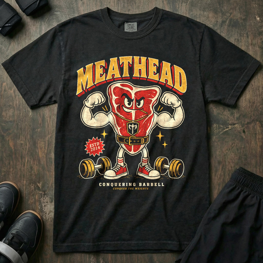Meathead - Relaxed Fit Tee front graphic in Black with a T-bone steak mascot flexing both arms in a lifting belt - Conquering Barbell