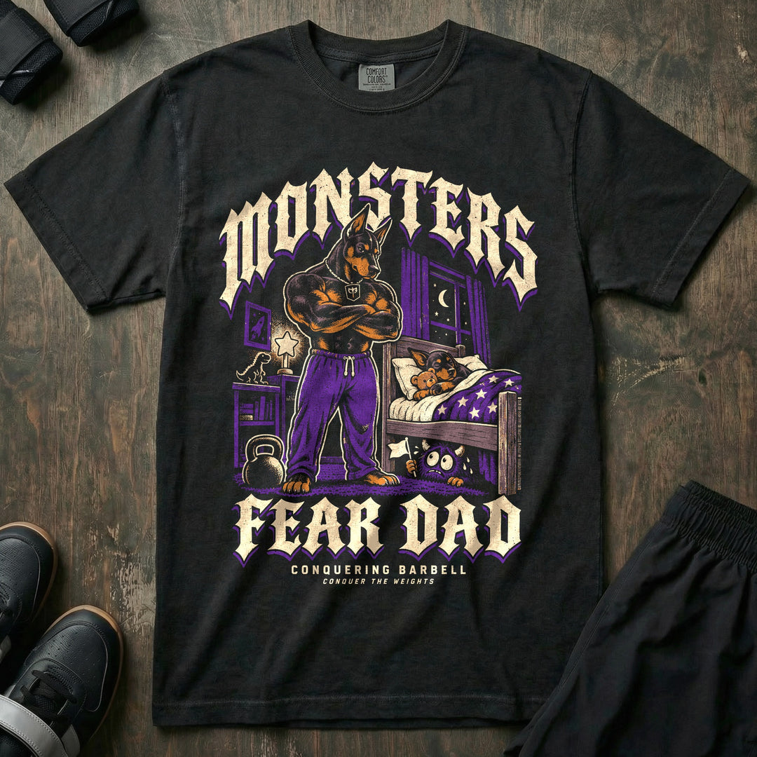 Monsters Fear Dad - Relaxed Fit Tee front graphic in Black with a doberman dad with crossed arms standing by a bed where a puppy sleeps while a small monster under the bed waves a white flag - Conquering Barbell