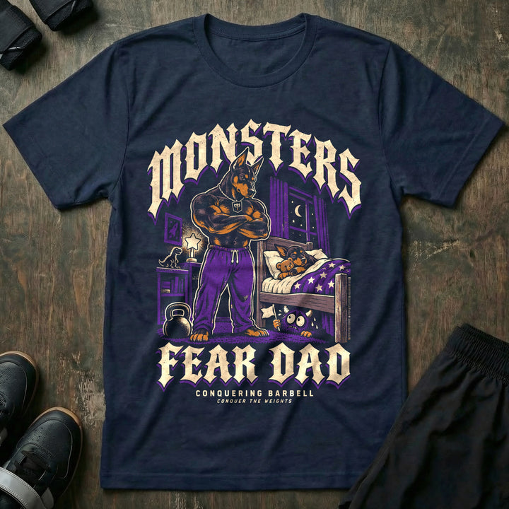 Monsters Fear Dad - Tee front graphic in Navy with a doberman dad with crossed arms standing by a bed where a puppy sleeps while a small monster under the bed waves a white flag - Conquering Barbell