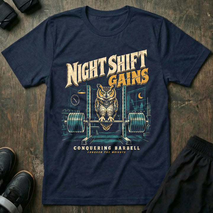 Night Shift Gains - Tee front graphic in Navy with a great horned owl perched on a loaded barbell in an empty gym at night - Conquering Barbell