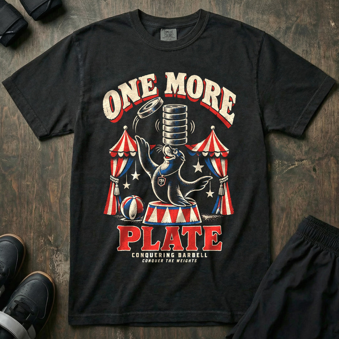 One More Plate - Relaxed Fit Tee front graphic in Black with a circus sea lion balancing a stack of weight plates on its nose and tossing on one more - Conquering Barbell