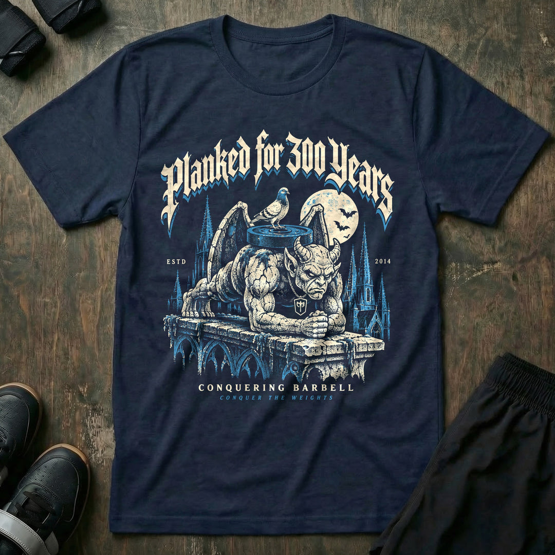 Planked for 300 Years - Tee front graphic in Navy with a stone gargoyle holding a weighted plank on a cathedral ledge - Conquering Barbell