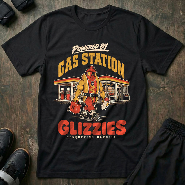 Powered by Gas Station Glizzies - Tee front graphic in Black with a muscular hot dog lifter walking out of a gas station under POWERED BY GAS STATION GLIZZIES - Conquering Barbell