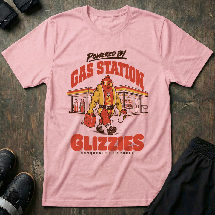 Powered by Gas Station Glizzies - Tee front graphic in Pink with a muscular hot dog lifter walking out of a gas station under POWERED BY GAS STATION GLIZZIES - Conquering Barbell