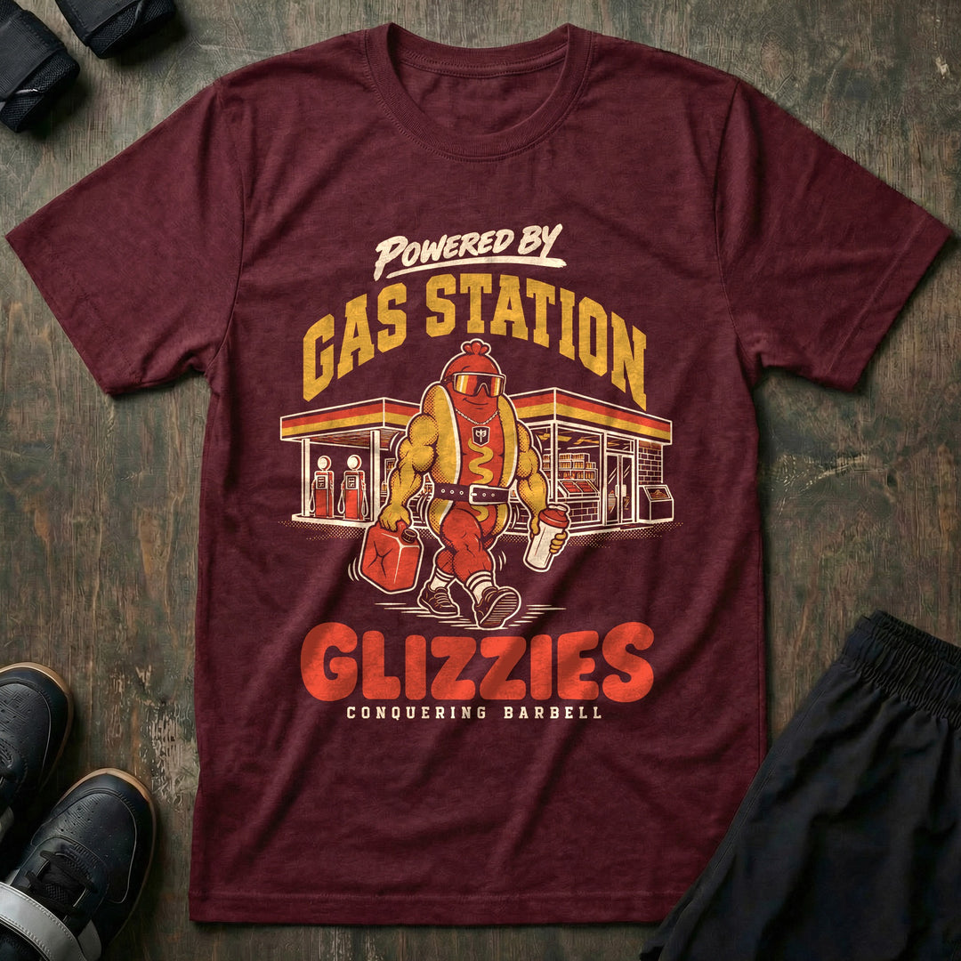 Powered by Gas Station Glizzies - Tee front graphic in Maroon with a muscular hot dog lifter walking out of a gas station under POWERED BY GAS STATION GLIZZIES - Conquering Barbell