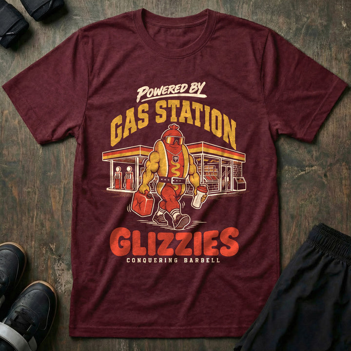 Powered by Gas Station Glizzies - Tee front graphic in Maroon with a muscular hot dog lifter walking out of a gas station under POWERED BY GAS STATION GLIZZIES - Conquering Barbell