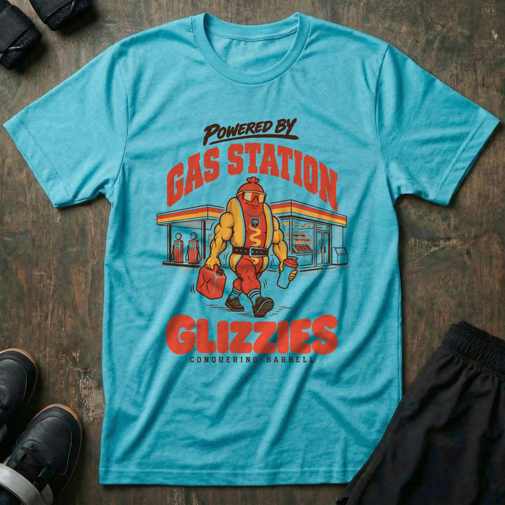 Powered by Gas Station Glizzies - Tee front graphic in Tahiti with a muscular hot dog lifter walking out of a gas station under POWERED BY GAS STATION GLIZZIES - Conquering Barbell