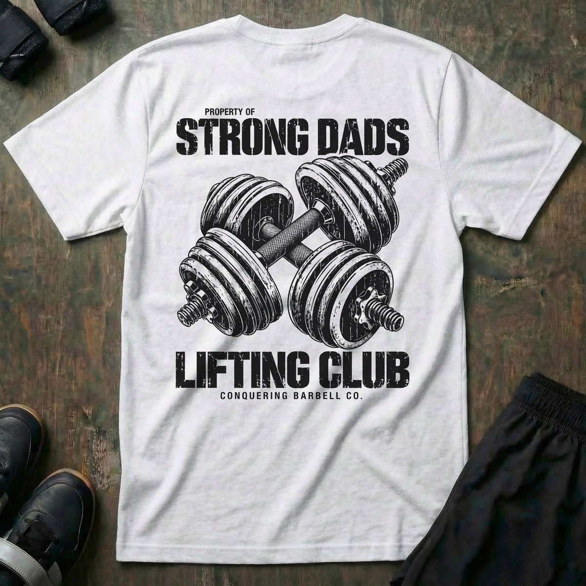 Property of Strong Dads Lifting Club tee in White: a pair of crossed dumbbells between PROPERTY OF STRONG DADS