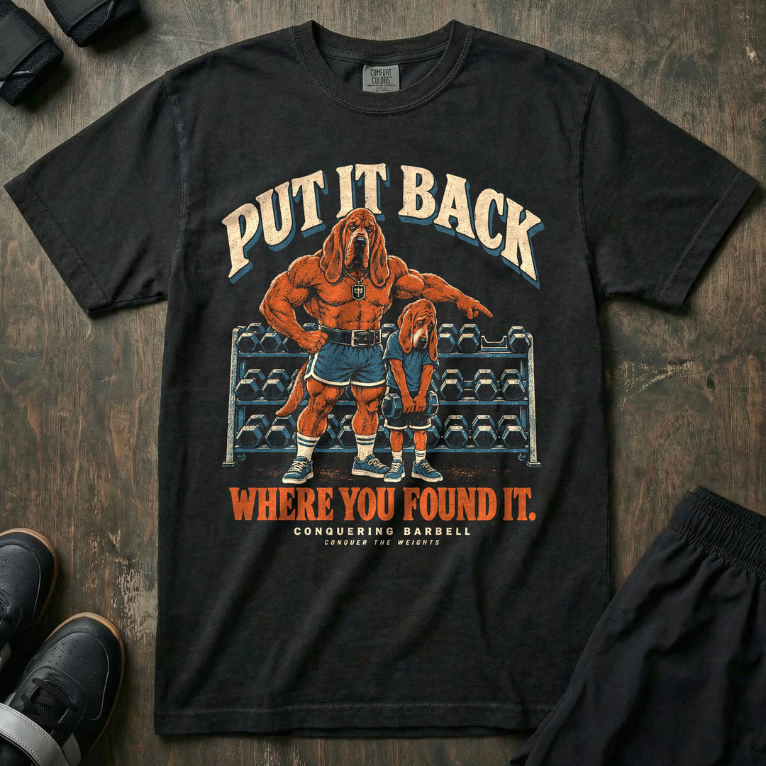 Put It Back Where You Found It - Relaxed Fit Tee front graphic in Black with a bloodhound dad pointing at a dumbbell rack while a young bloodhound holds a dumbbell with his head down - Conquering Barbell