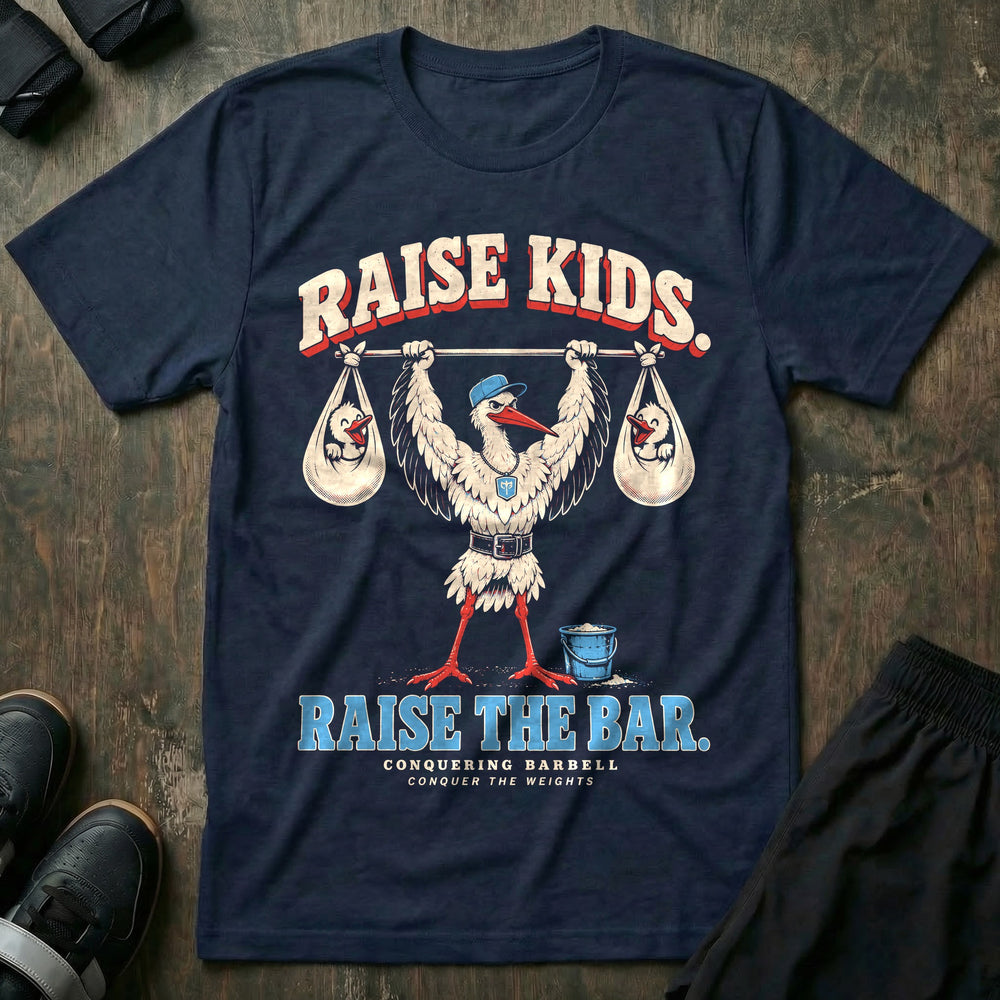 Raise Kids. Raise the Bar - Tee front graphic in Navy with a stork dad in a ball cap pressing a barbell overhead with a baby bundle hanging from each end - Conquering Barbell