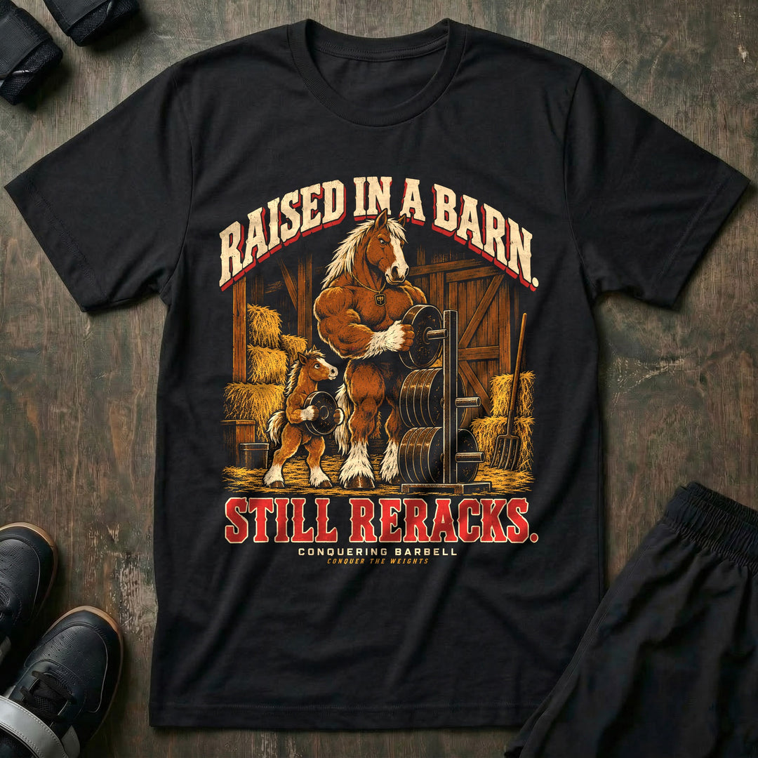 Raised in a Barn. Still Reracks - Tee front graphic in Black with a Clydesdale horse dad putting a weight plate on a rack in a barn while a foal carries another plate - Conquering Barbell