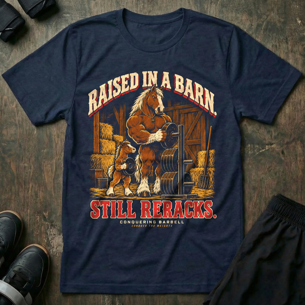 Raised in a Barn. Still Reracks - Tee front graphic in Navy with a Clydesdale horse dad putting a weight plate on a rack in a barn while a foal carries another plate - Conquering Barbell