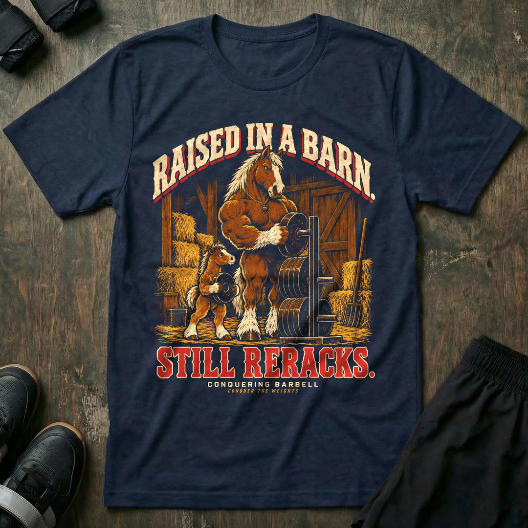Raised in a Barn. Still Reracks - Tee front graphic in Navy with a Clydesdale horse dad putting a weight plate on a rack in a barn while a foal carries another plate - Conquering Barbell