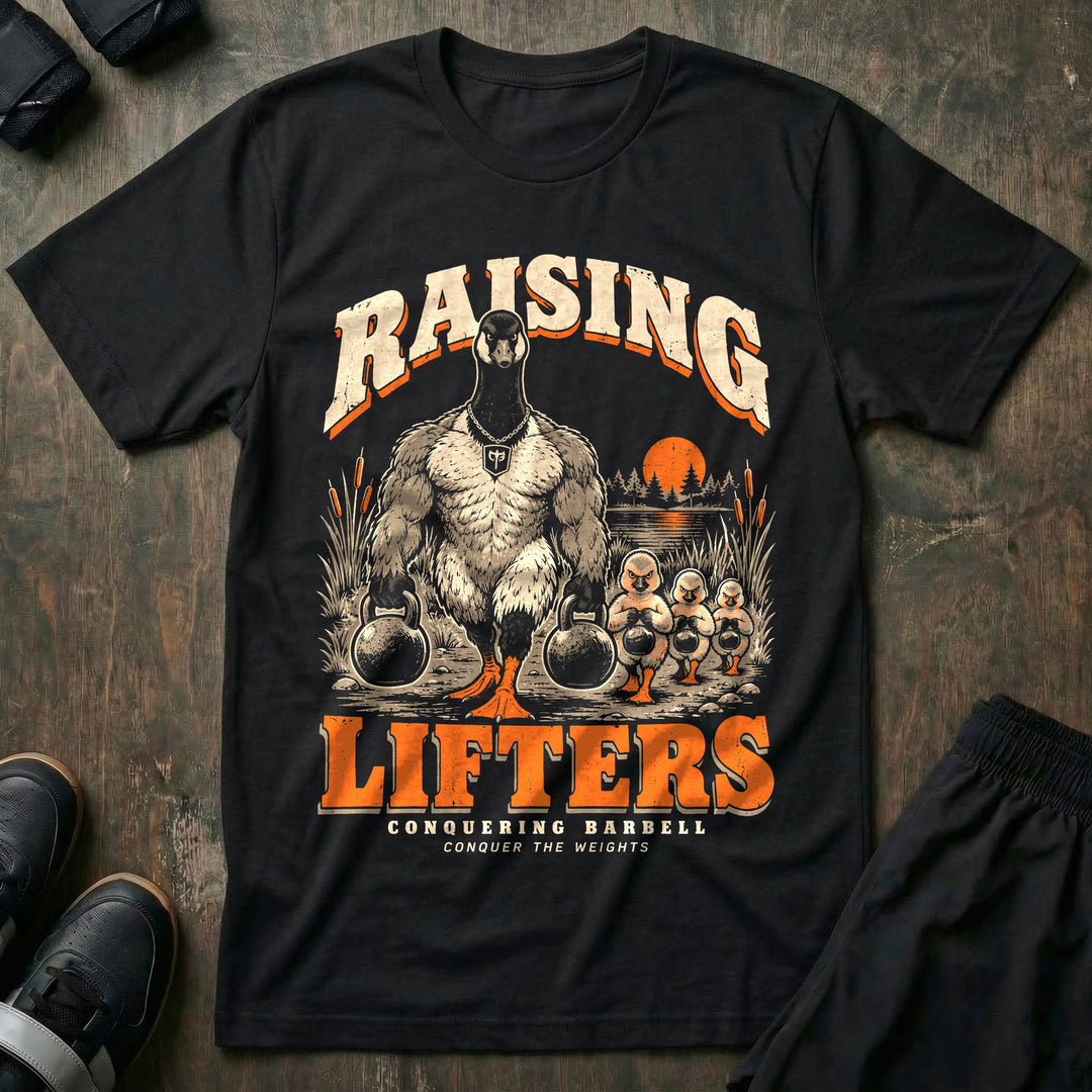 Raising Lifters - Tee front graphic in Black with a goose dad carrying two kettlebells along a marsh followed by three goslings carrying small kettlebells - Conquering Barbell