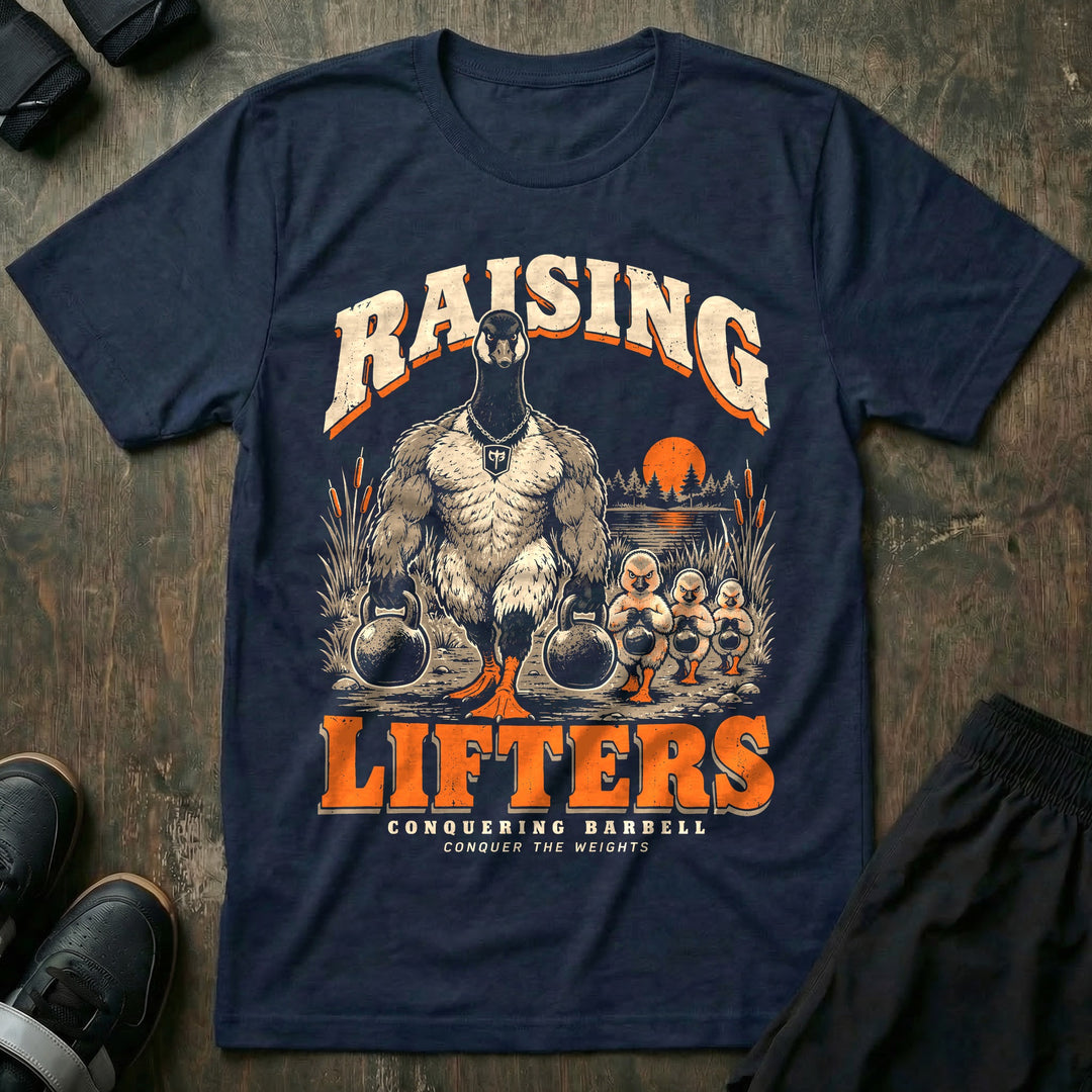 Raising Lifters - Tee front graphic in Navy with a goose dad carrying two kettlebells along a marsh followed by three goslings carrying small kettlebells - Conquering Barbell