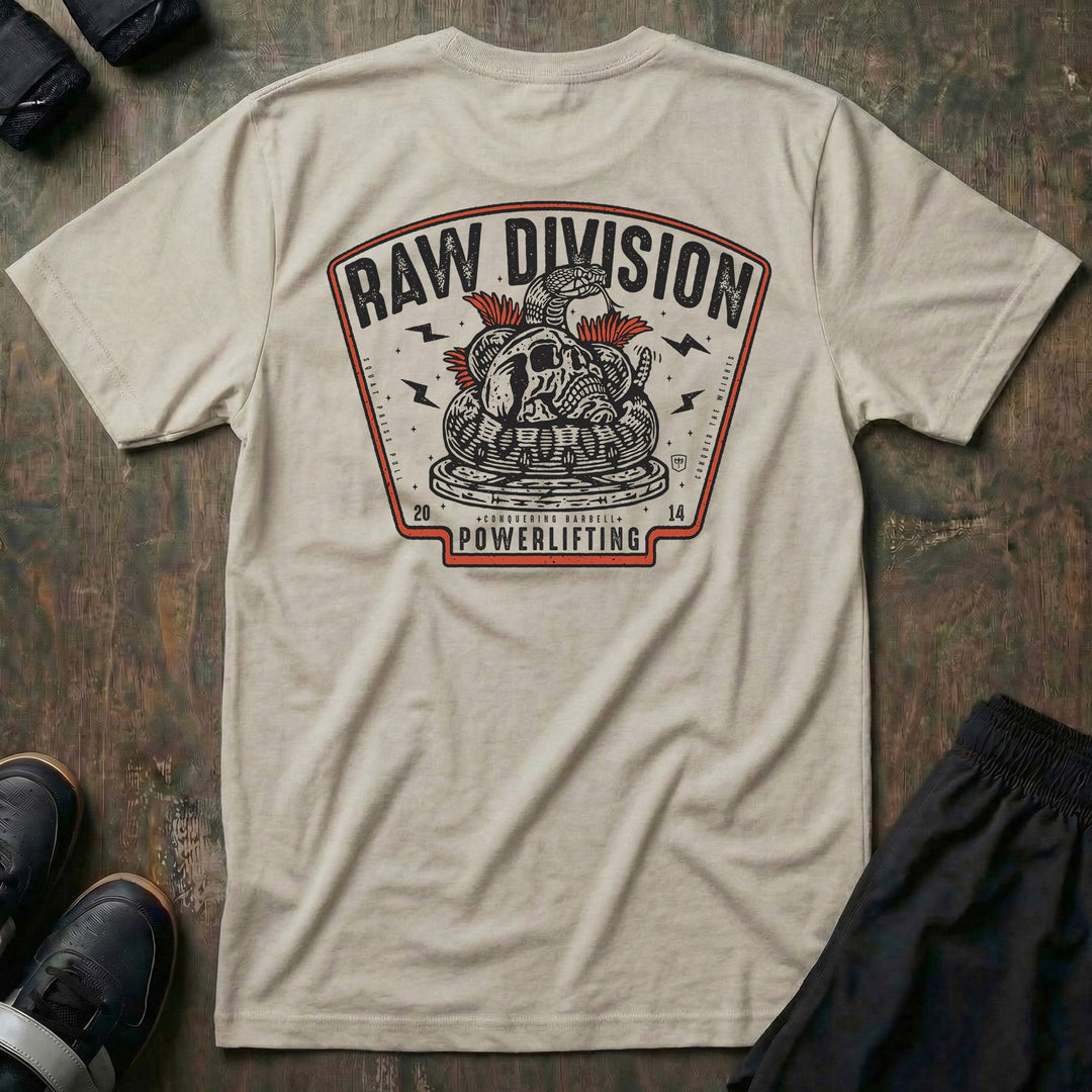 Raw Division tee in Sand: a coiled rattlesnake wrapped around a skull on a stack of weight plates inside a bold badge