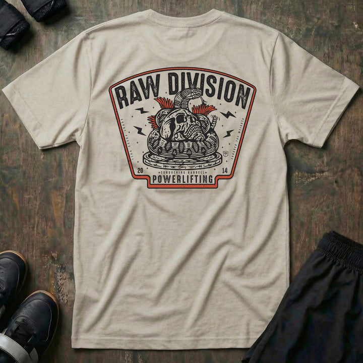 Raw Division tee in Sand: a coiled rattlesnake wrapped around a skull on a stack of weight plates inside a bold badge