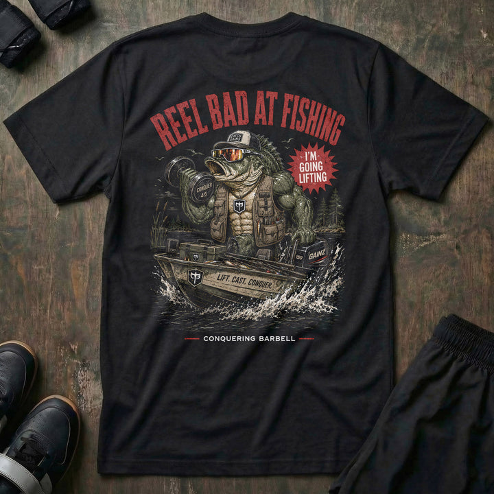 Reel Bad at Fishing tee in Black: a jacked gator in a cap and vest cruising in a fishing boat with a dumbbell in hand