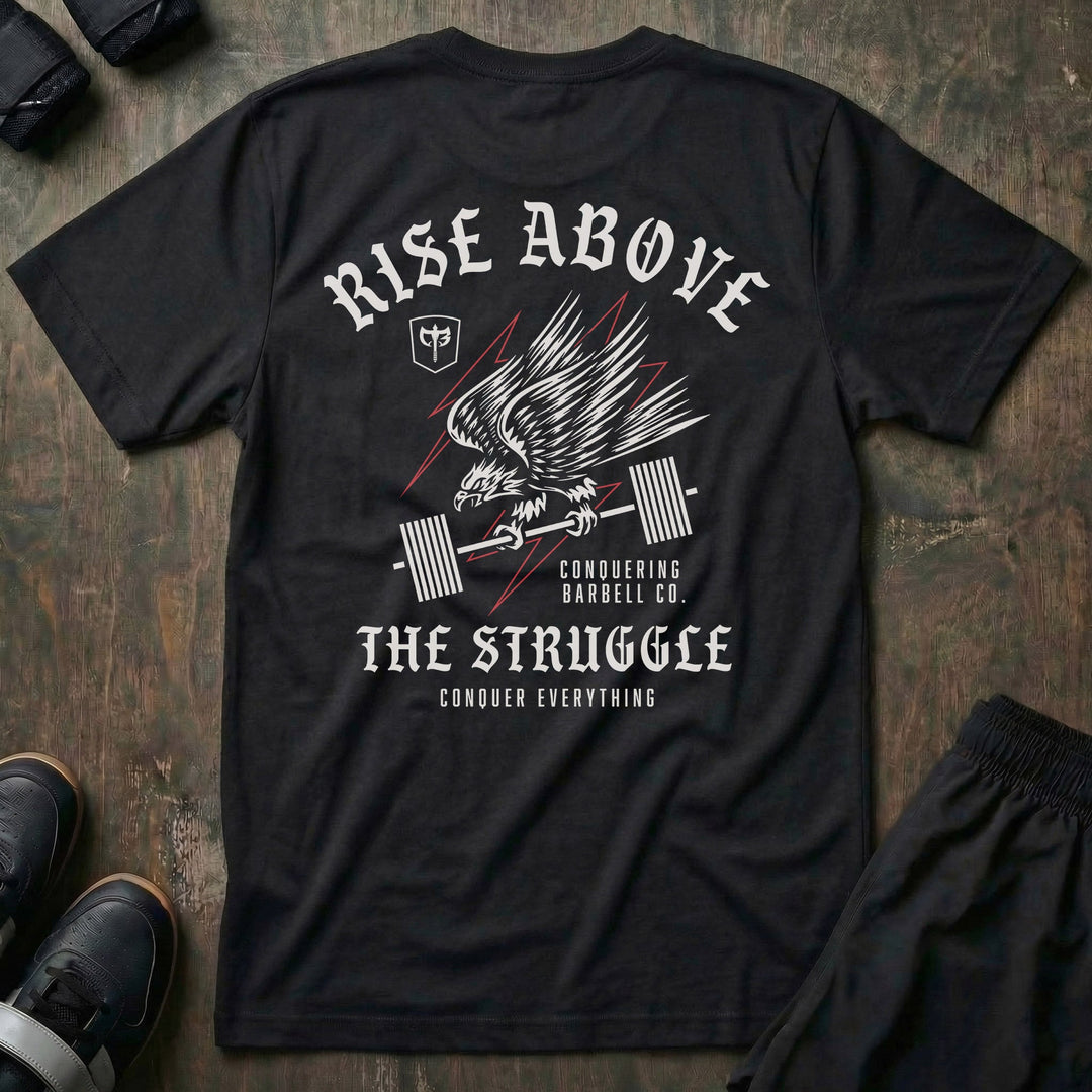 Rise Above the Struggle tee in Black: a fierce eagle clutching a loaded barbell as lightning bolts cut through the graphic