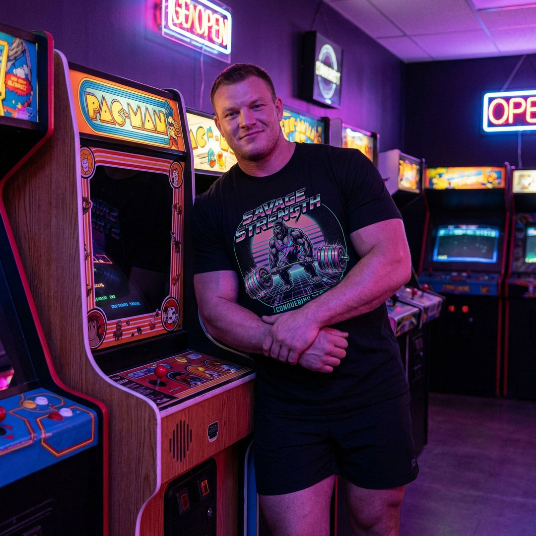 Savage Strength tee in Black: a retro 80s-style gorilla deadlifting heavy inside a neon circle over a glowing grid