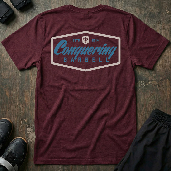Script Logo Summer Vibes Edition tee in Maroon: the classic Conquering Barbell script logo inside a bold badge frame
