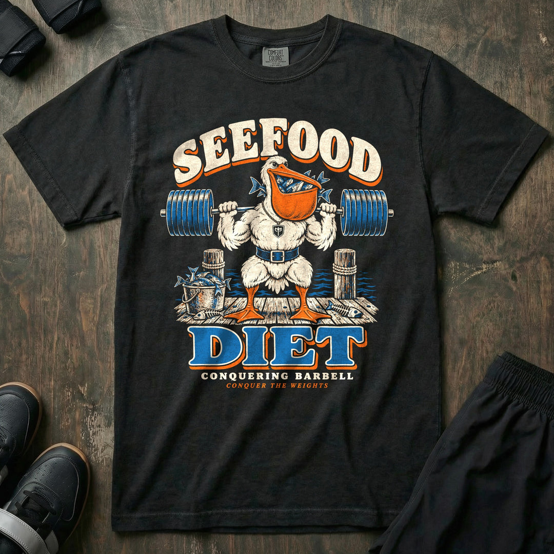 Seefood Diet - Relaxed Fit Tee front graphic in Black with a pelican with a bill full of fish squatting a loaded barbell on a dock - Conquering Barbell