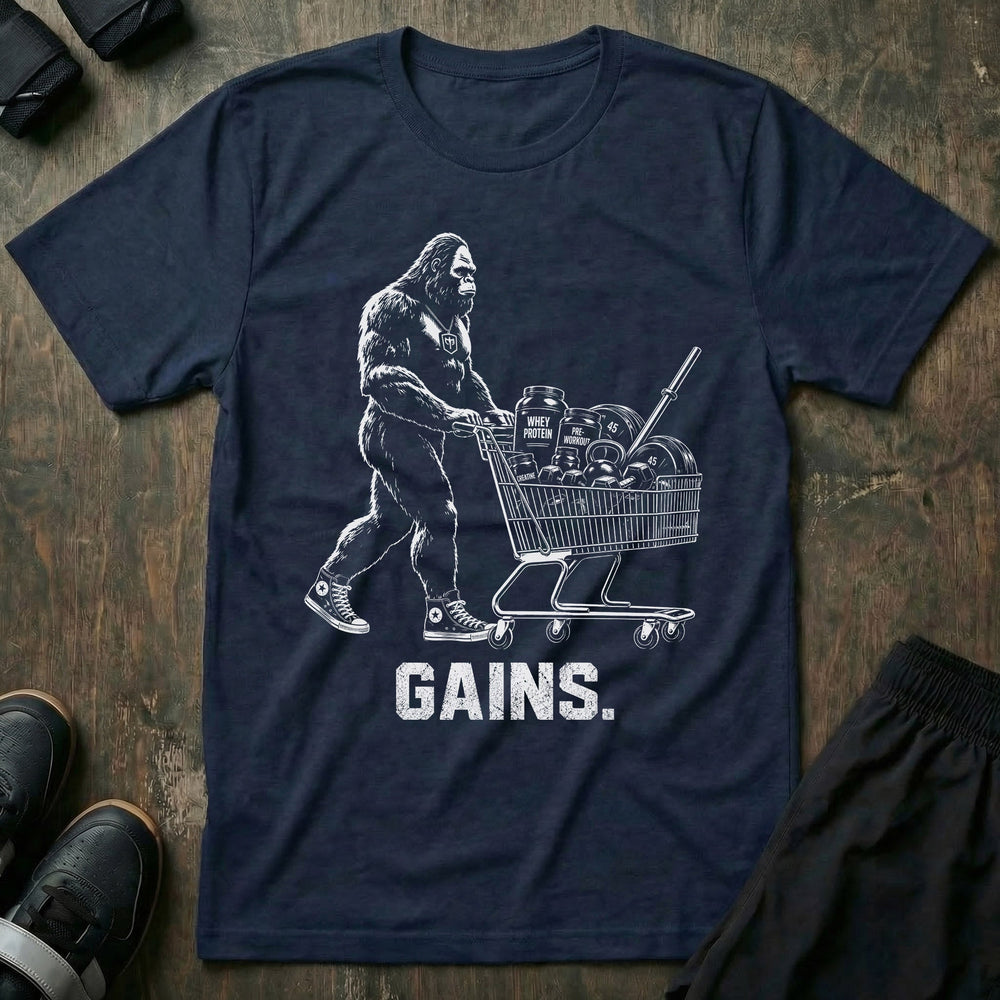 Shopping for Gains tee in Navy: Bigfoot in high tops pushing a shopping cart loaded with protein