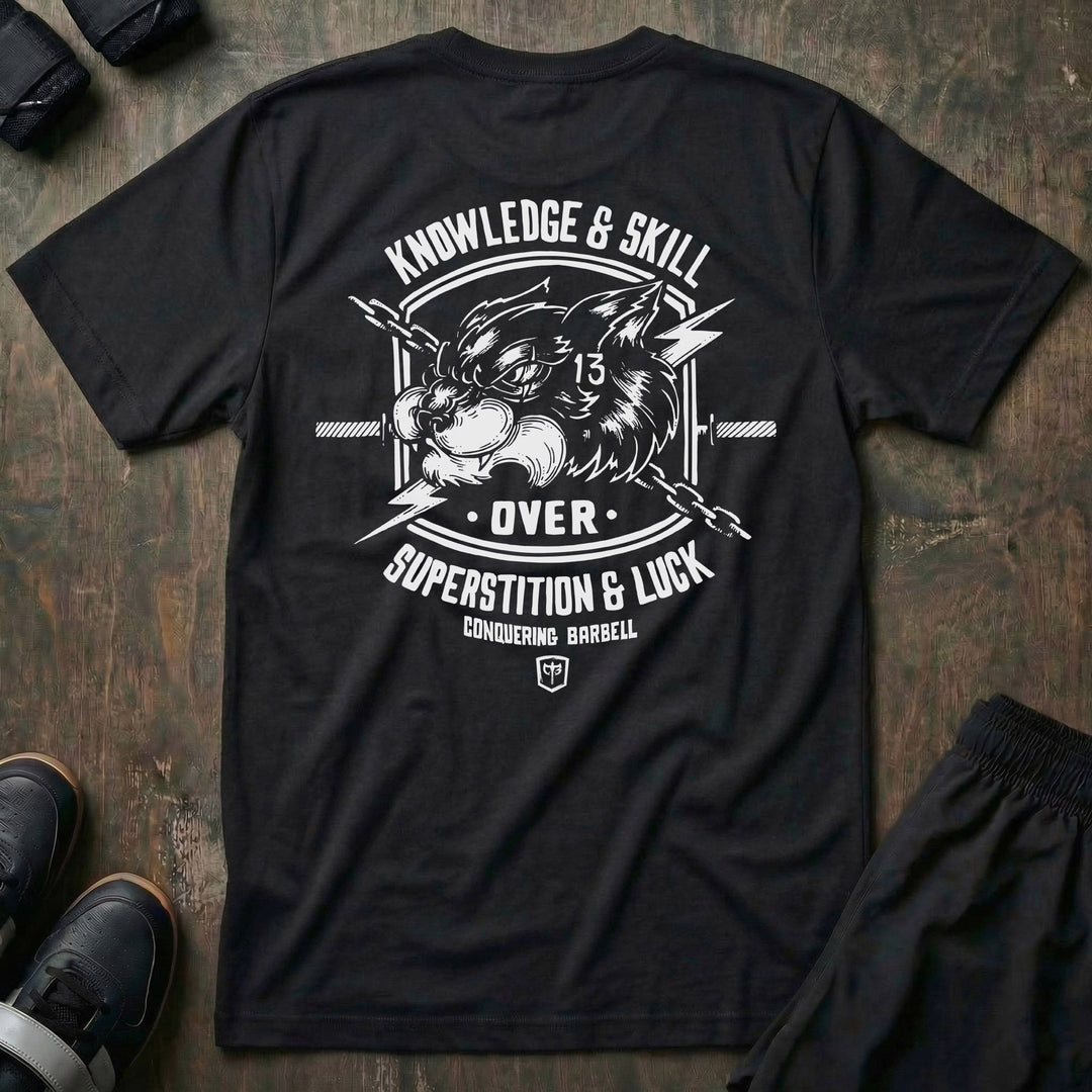 Skill Over Luck tee in Black: a snarling black cat marked with 13 flanked by crossed barbells and lightning bolts