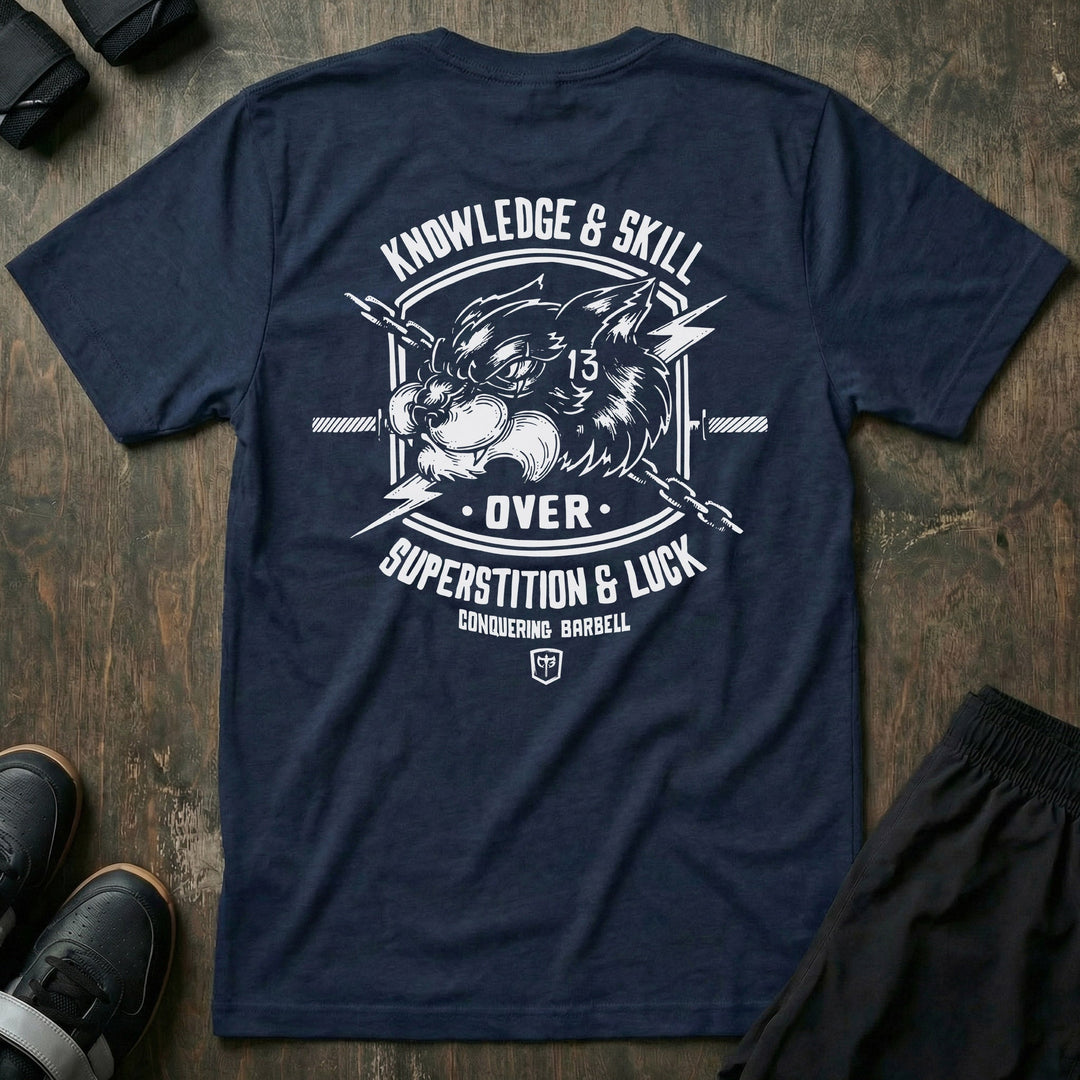 Skill Over Luck tee in Navy: a snarling black cat marked with 13 flanked by crossed barbells and lightning bolts