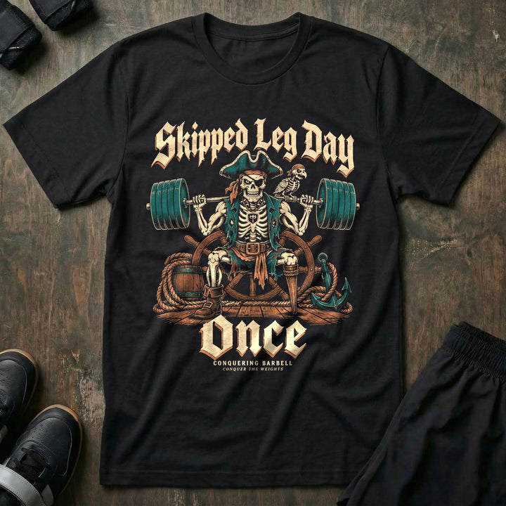 Skipped Leg Day Once - Tee front graphic in Black with a peg-legged skeleton pirate with a loaded barbell on his back - Conquering Barbell